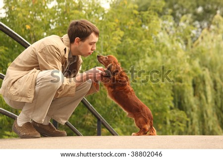 Young man plays with his adorable dachshund  outdoor