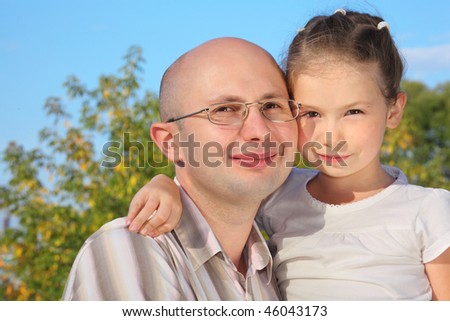 handsome man with his little daughter in early fall park.