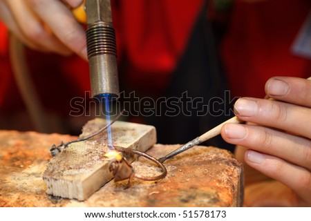 Master soldering jeweller ornament. Picture of hands and product close up.