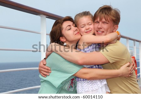 happy family with daughter on cruise liner deck embracing each other, half body