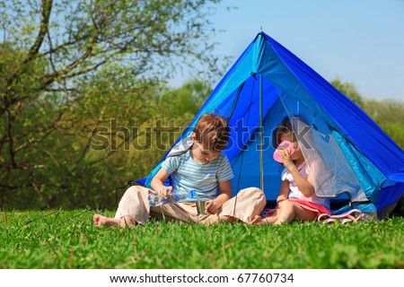brother and sister drinking water in tent outdoor