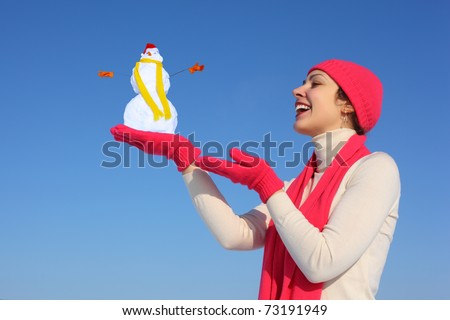 Young woman in red gloves with snowman on blue sky collage