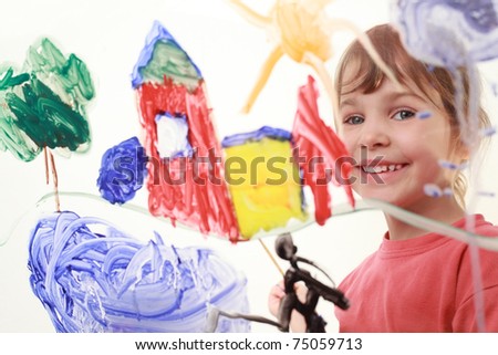 beautiful little girl in red t-shirt paints on glass and smiles, house, tree, sun