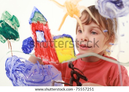 beautiful little girl in red t-shirt paints on glass, house, tree, sun