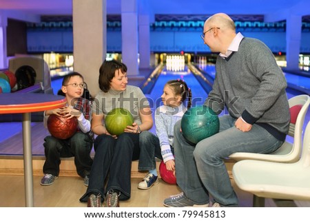Family from four persons in rest and communicate in bowling club