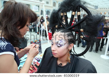 MOSCOW - OCTOBER 2: Visagiste makes makeup for model with punk hairstyle at XVII International Festival \
