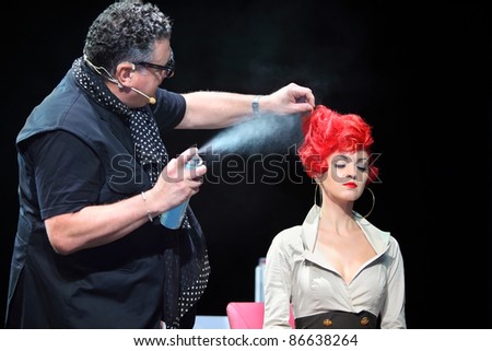 MOSCOW - SEPTEMBER 6: Tim Hartley sprays hairspray on red hair of model at Davines Hair Show 2010, on September 6, 2010 in Moscow, Russia.