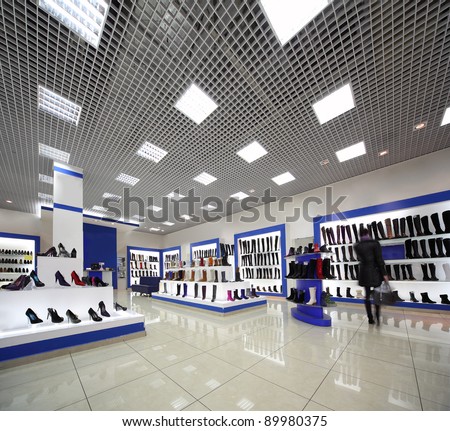Inside spacious lighting shoes shop with models on white shelves