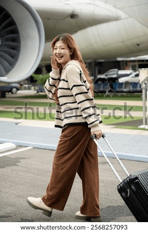 Similar – Image, Stock Photo Female passenger carrying the hand luggage bag, walking the airplane boarding corridor.