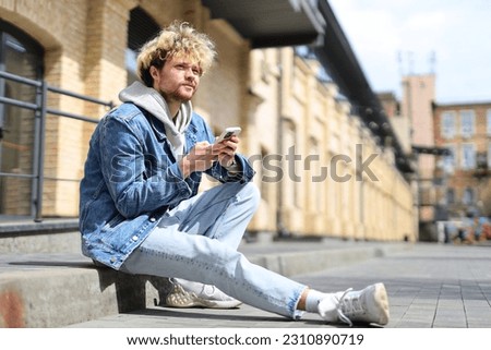 Similar – Foto Bild Mann schaut auf der Straße auf sein Telefon.