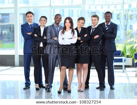 Happy young business woman with her team in background