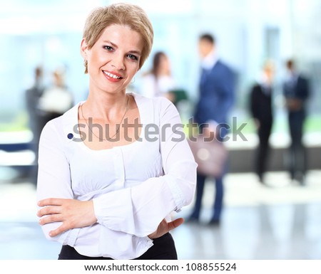 Young pretty woman smiling with team in blurred background