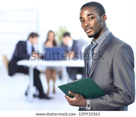 Portrait of a successful american african businessman smiling leading his team