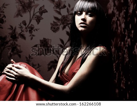 Beautiful woman seated in dark room