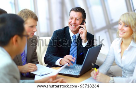 business man speaking on the phone while in a meeting