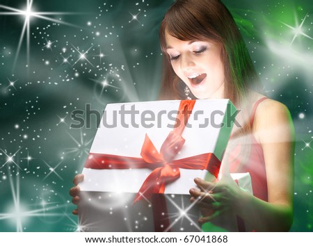Beautifull girl opening x-mass magic present. Christmas