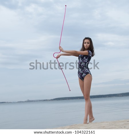 young professional gymnast woman dance with skipping rope - outdoor sand beach
