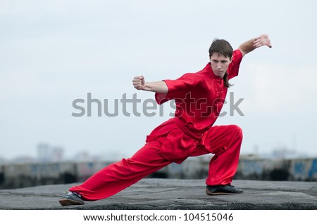 Shaolin warriors wushoo man in red practice martial art outdoor. Kung fu