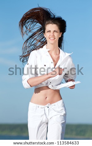 Beautiful young sport woman running in sea coast on sunny summer day
