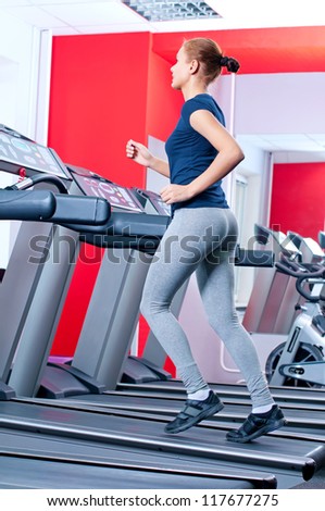 Young woman at the gym exercising. Run on machine