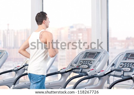 Young man at the gym exercising. Run on on a machine.