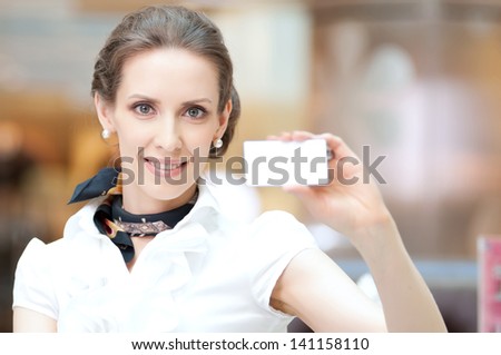 Businesswoman showing and handing a blank business card. Office background.