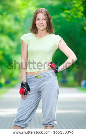 Woman skating in park. Girl going rollerblading staying in a park. Sporty caucasian woman in outdoor fitness activities.