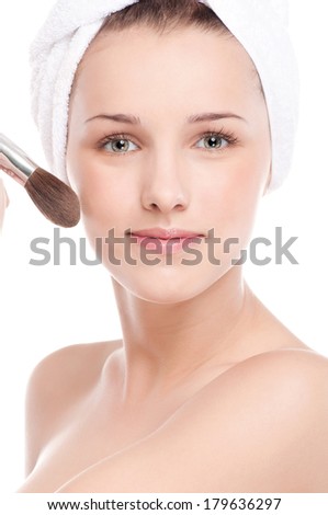 Close-up portrait of young beautiful woman with brush for make-up. Cheek zone