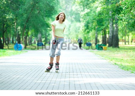 Roller skating sporty girl in park rollerblading on inline skates.  Caucasian woman in outdoor fitness activities.