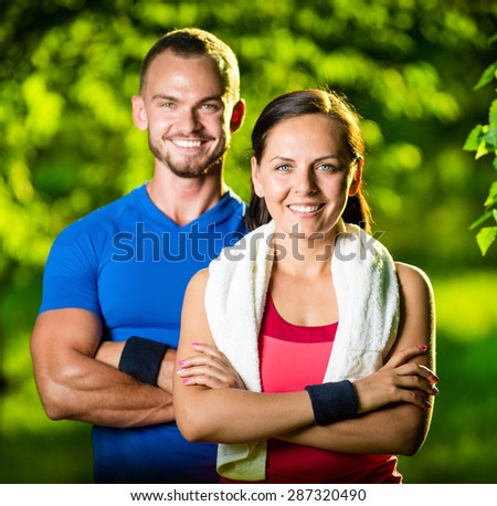 Athletic man and woman after fitness exercise. Beautiful young couple in sports clothing after outdoor exercises. White towel.