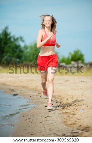 Young lady running. Woman runner running at the sunny summer sand beach. Workout near ocean sea coast. Beautiful fit girl. Fitness model caucasian ethnicity outdoors. Weight loss exercise. Jogging.