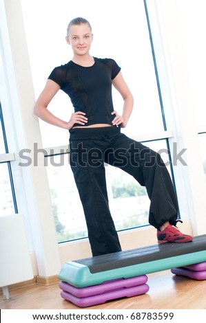 Young woman doing aerobic exercises at the sport gym