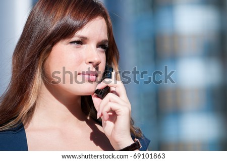 Beautiful businesswoman make call by mobile cell phone. Outdoor, over city.