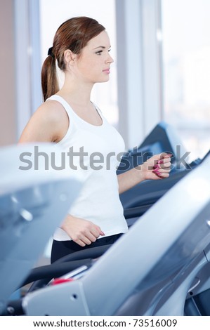 Young woman at the gym exercising. Run on on a machine.