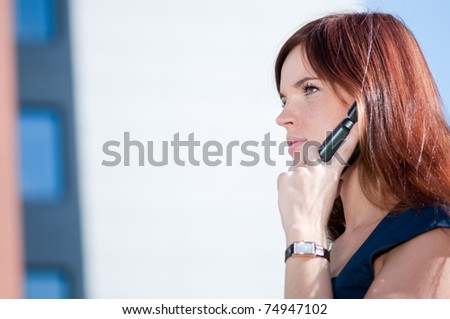 Beautiful businesswoman make call by mobile cell phone. Outdoor, over city.