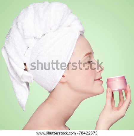 Beautiful woman smell jar of moisturizer cream. Close-up fresh young woman face