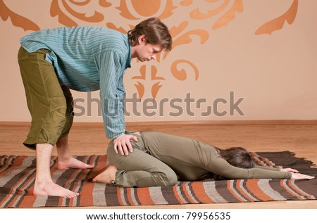 Two young man and woman couple doing yoga. Massage