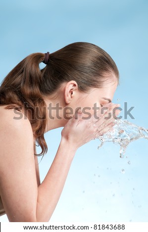 Close-up portrait of beautiful emotional woman washing her face