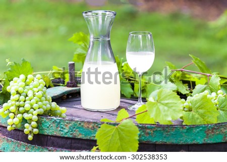 wine glass and carafe with wine cider standing on cask