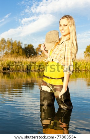 fisher woman standing in pond
