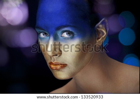Young girl with elven ears with strong blue and golden makeup