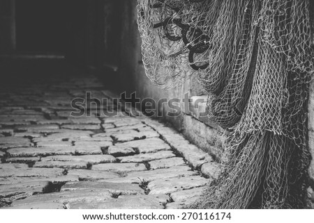 Rovinj old town, Croatia. Fishing nets hanging on the door. Black and white photo.