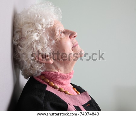 Dreaming old woman. isolated against grey background