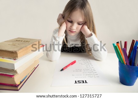 Little girls studying, thinking hard on a math test