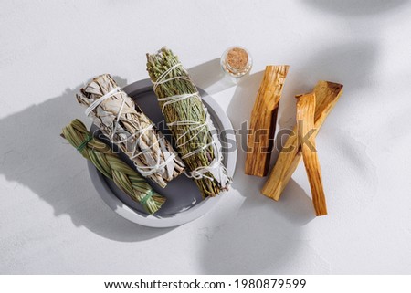 White sage, cedar, sweetgrass, and Palo Santo sticks tied by a bunch on a light background. Set of incense for fumigation, illuminated by the sun. Top view. Organic incense from Latin America. Foto stock © 