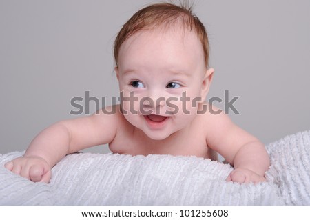 Portrait of a cute little baby boy lying on front