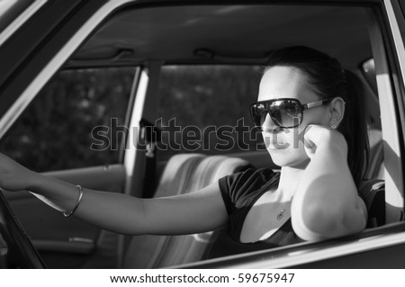 Young woman driving an old car. Black and white - retro style image