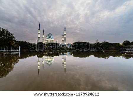 a beautiful view of Sultan Salahuddin Abd Aziz Mosque with reflection from the lake during sunrise