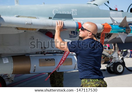 BAGOTVILLE, QUEBEC/CANADA  - JUNE 22: Bagotville Airshow. A technician check a missil on Royal Canadian Air Force (RCAF) CF-18 in Bagotville, Quebec, Canada on June 22, 2013.