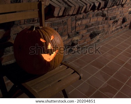 A jack-o-lantern sitting in a chair on a porch